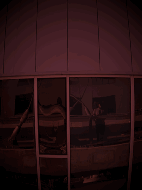 A Gif of a scene I captured of me on the Viaduct bridge zooming in on a reflection of myself as a Metro bus speeds behind me on a loop of zoom in and zoom out.